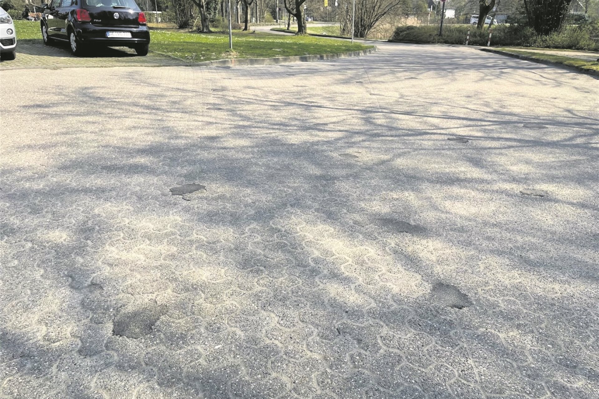 Viele rätseln, was diese kleinen schwarzen Flecken zwischen den Pflastersteinen auf dem Copa-Parkplatz zu bedeuten haben.