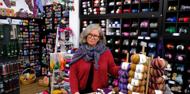 Yvonne Stajer von „Wollfühl“ in ihrem Laden, umgeben von ganz viel bunter Wolle.