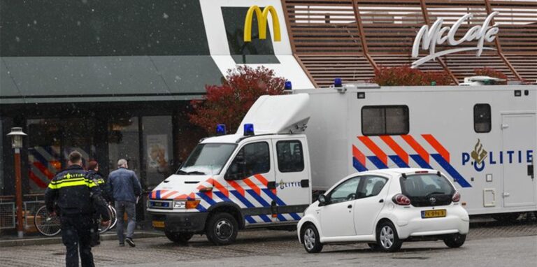 Polizisten ermittelt am Tatort, wo zwei Männer nach Schüssen in einem Schnellrestaurant ums Leben gekommen sind.