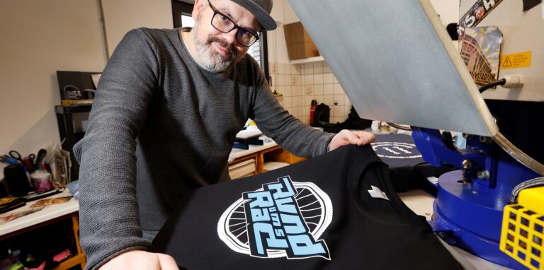 Sprüche rund ums Rad: Textildrucker Alexander Kreuser, Inhaber der Firma „Kamen-Shirts“, verzeichnet eine große Nachfrage nach Radfahrer-Motiven.