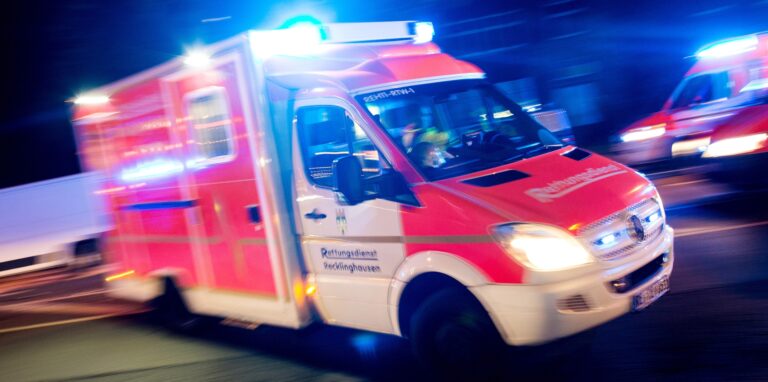 Ein Rettungswagen der Feuerwehr fährt in Recklinghausen mit Blaulicht durch eine Straße.