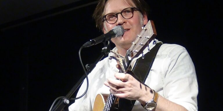 Philip Omlor mit Gitarre auf der Bühne