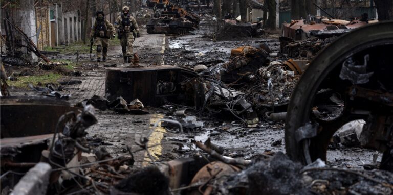 Zwei ukrainische Soldaten gehen auf einer Straße, die übersät ist mit zerstörten russischen Militärfahrzeugen. In der ukrainischen Stadt Butscha, 25 Kilometer nordwestlich der Hauptstadt Kiew, bietet sich nach dem Rückzug der russischen Armee ein Bild des Grauens.
