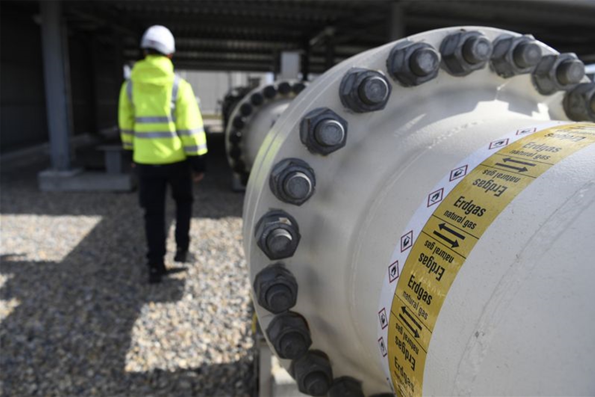 Ein Mitarbeiter geht an einem Teil einer Erdgasleitung am Gelände der Gas Connect Austria Verdichterstation.