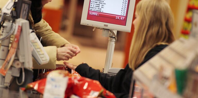 Ein Kassiererin nimmt in Köln (Nordrhein-Westfalen) in einem Supermarkt das Geld einer Kundin entgegen.