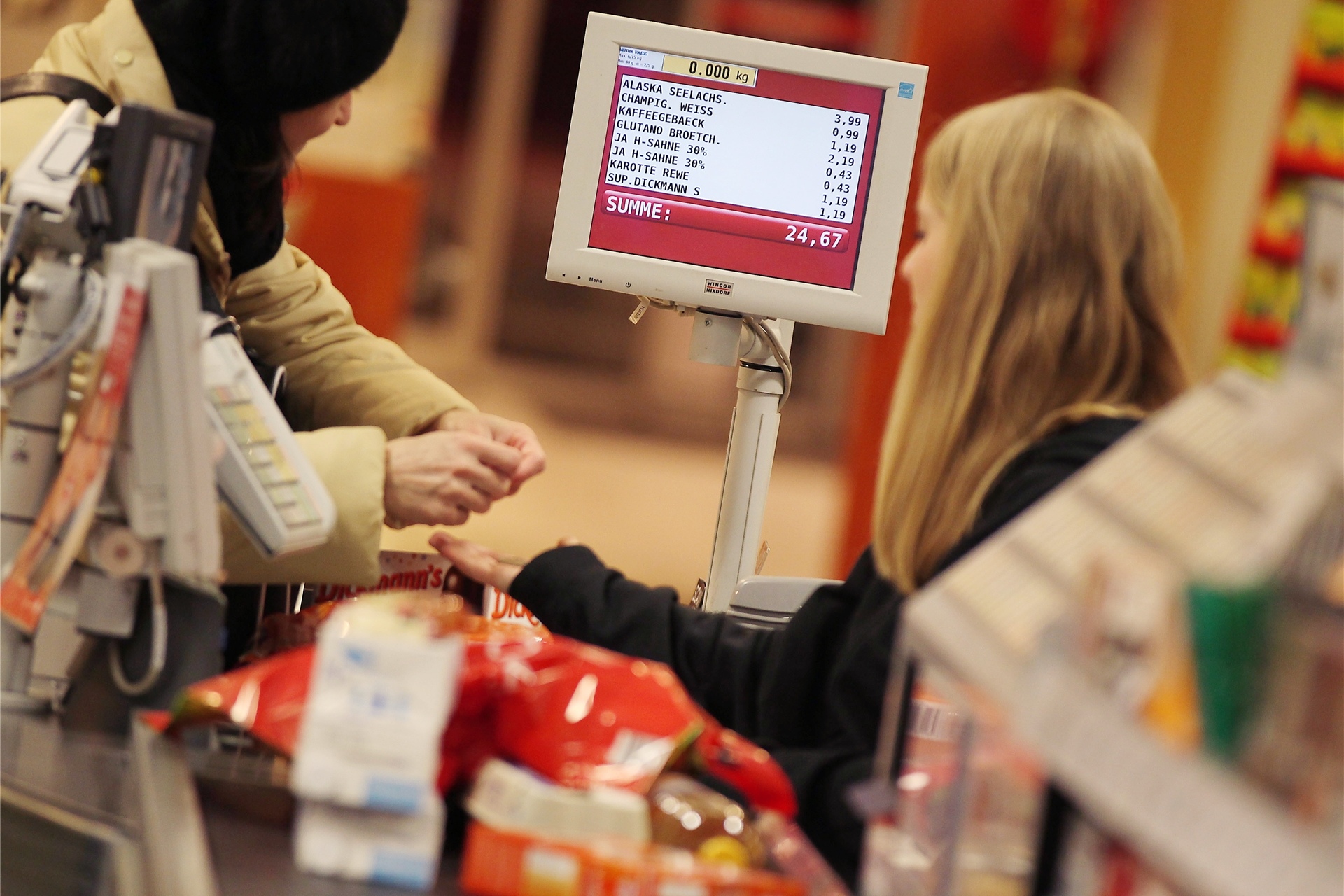 Ein Kassiererin nimmt in Köln (Nordrhein-Westfalen) in einem Supermarkt das Geld einer Kundin entgegen.