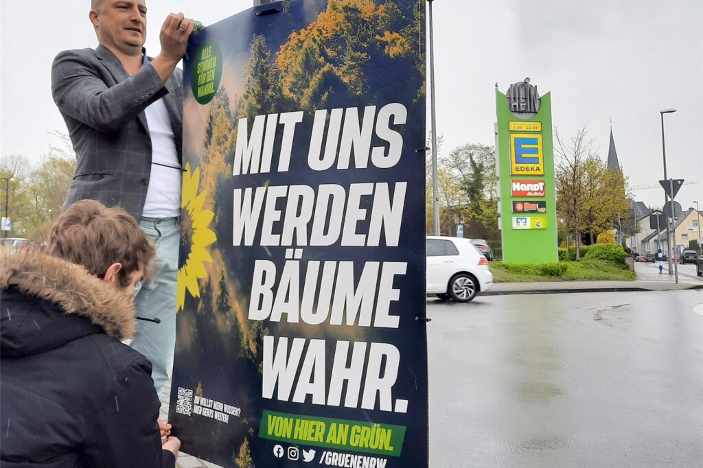 Zwei Parteimitglieder der Grünen hängen in NRW ein Plakat mit der Aufschrift Zwei Parteimitglieder der Grünen hängen in NRW ein Plakat mit der Aufschrift
