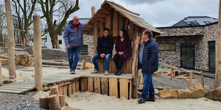 Auf dem Außengelände des Junikum-Kindergartens in Oer-Erkenschwick nehmen Thomas Kurth, Martin Petrat, Bianca König und Markus Solbach das neue Spielhaus in Augendschein,