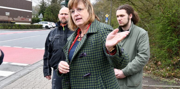 Drei Personen vor der „Gesamtschul-Ampel“ an der Brockenscheidter Straße.