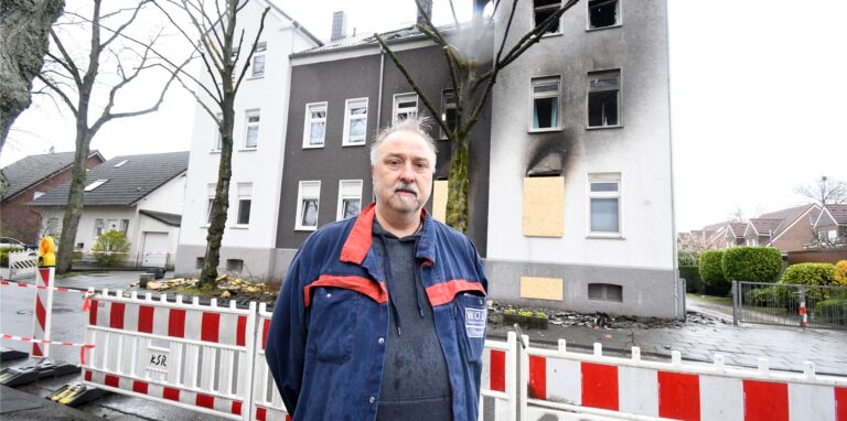 Ein Mann, Thorsten Plagemann, steht vor einem Haus in Recklinghausen, in dem es gebrannt hat.