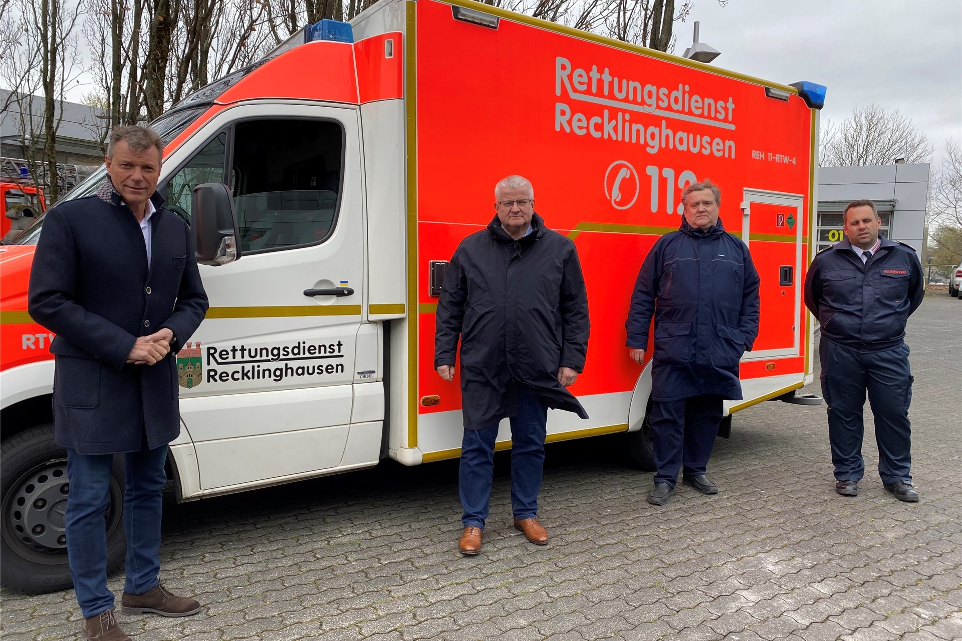 Bürgermeister Christoph Tesche, Erster Beigeordneter Ekkehard Grunwald, Ausschussvorsitzender für Ordnung, Feuerwehr und Katastrophenschutz Claus Beeking und Thorsten Schild, Leiter der Feuerwehr, stehen vor dem Einsatzfahrzeug, das in die Ukraine gebracht wird.