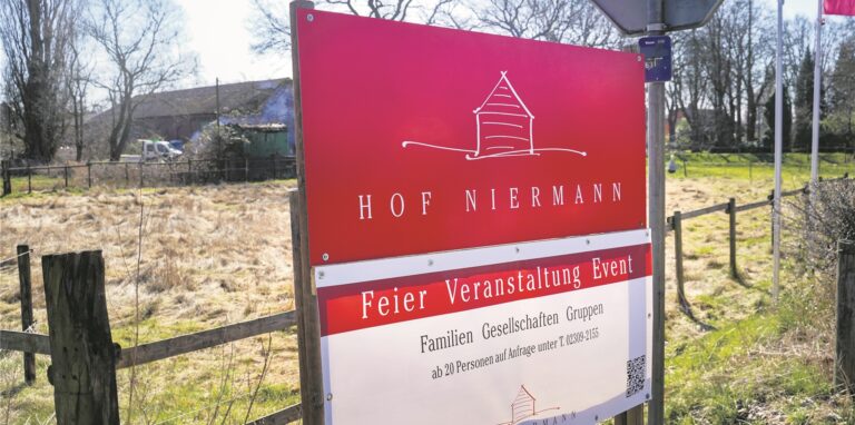 Ein Schild mit der Aufschrift „Hof Niermann – Feier Veranstaltung Event“ weist im Vordergrund eines Bauernhofes in Waltrop auf die Feier-Location hin.