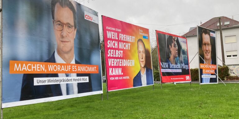 Man sieht, dass man am Engelsburgplatz nichts mehr sieht außer riesiger Wahlplakate zur Landtagswahl. Die stehen auf dem Platz in drei Reihen angeordnet.