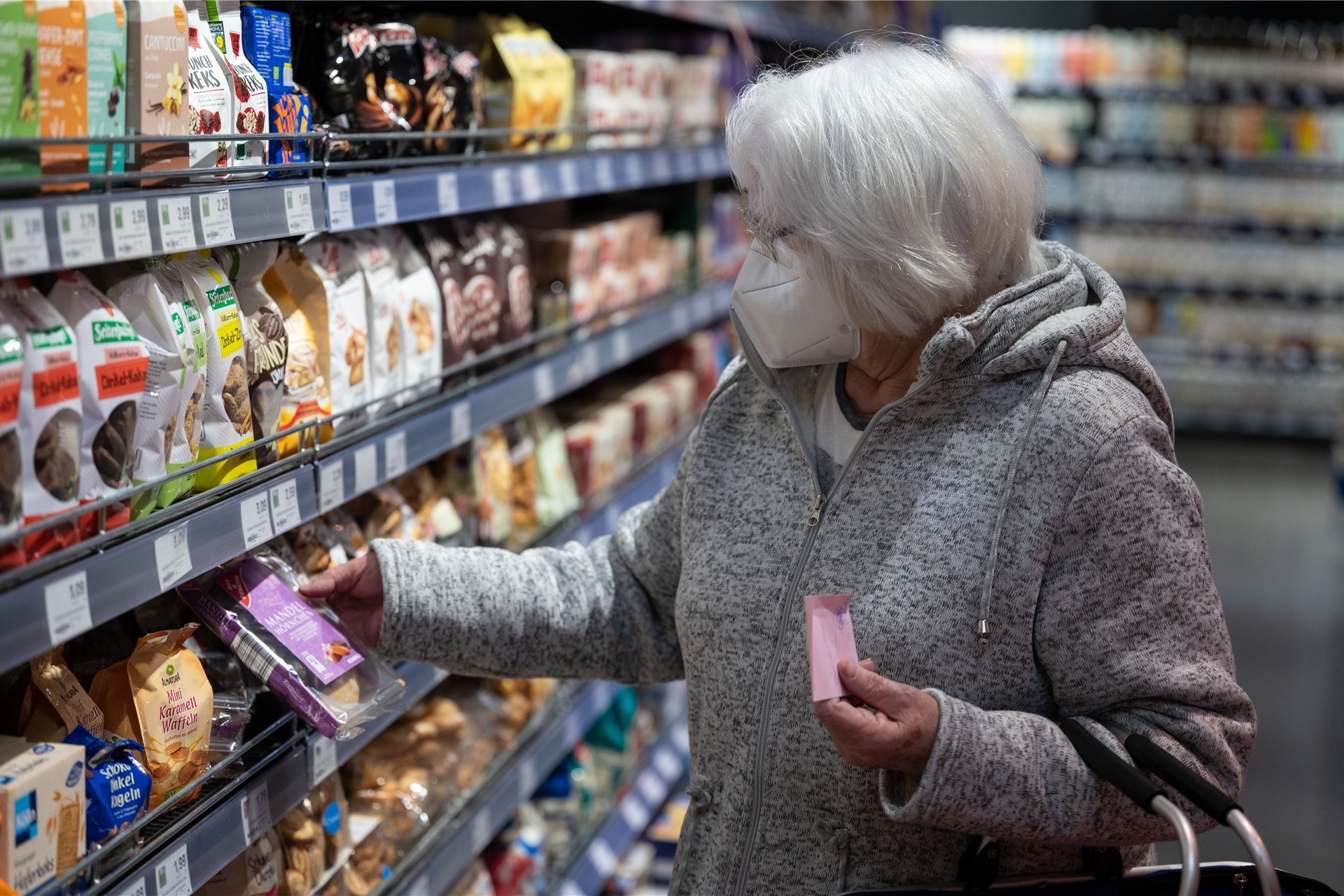 Eine Kundin kauft im Einzelhandelsgeschäft „Staufers Markthalle“ ein und trägt eine FFP2-Maske. Nach knapp zwei Jahren ist in großen Teilen Deutschlands die Maskenpflicht im Einzelhandel entfallen. Beschäftigte und Kunden entscheiden selbst, ob sie weiterhin eine Maske tragen.