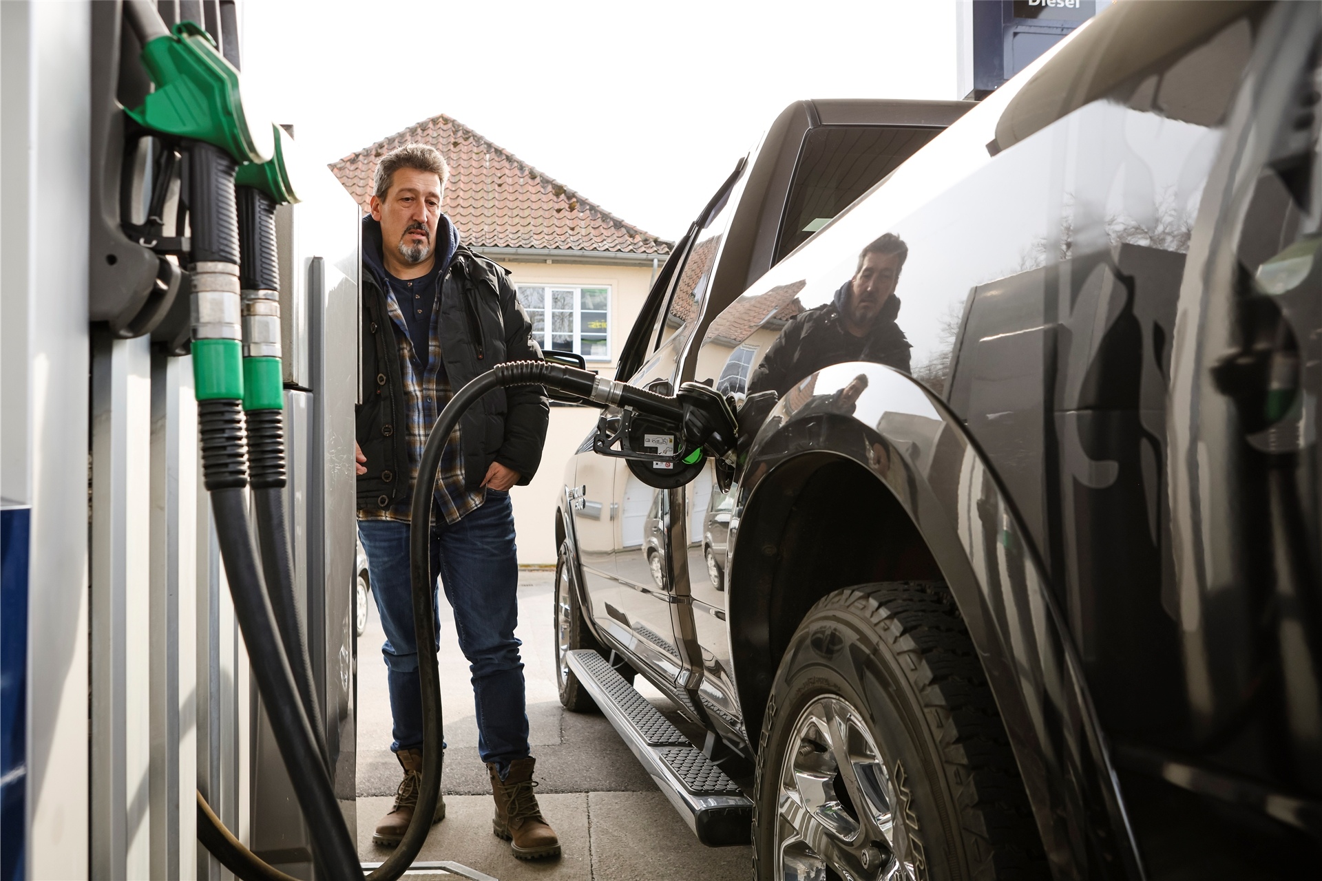 Ein Mann betankt sein Auto an einer Tankstelle.