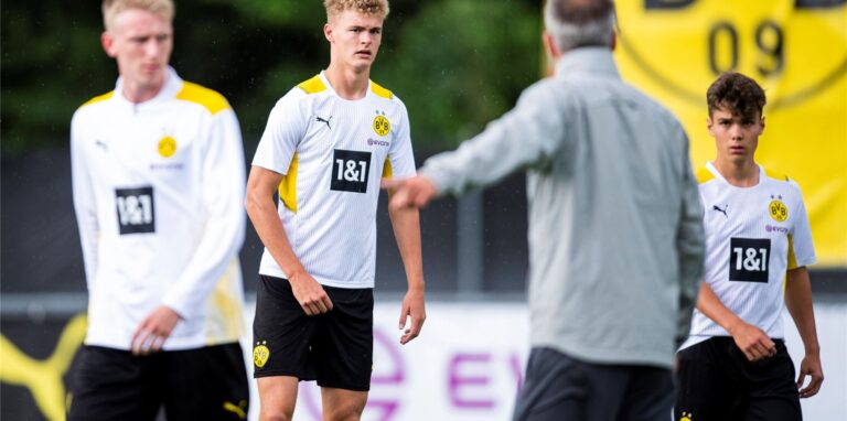 BVB-Trainer Marco Rose steht mit dem Rücken zur Kamera und erteilt den BVB-Youngstern um Tom Rothe Anweisungen.