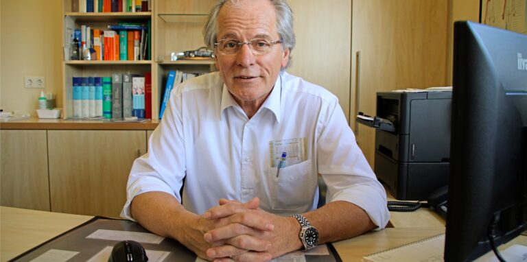 Hausarzt Dr. Georg Friemann am Schreibtisch.