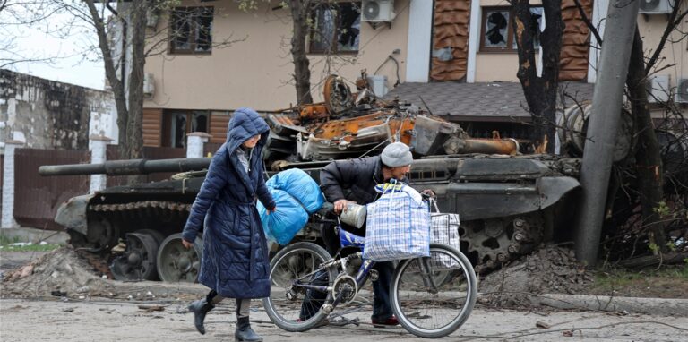 Zivilisten gehen an einem Panzer vorbei, der bei schweren Kämpfen in einem von den von Russland unterstützten Separatisten kontrollierten Gebiet in Mariupol zerstört wurde.