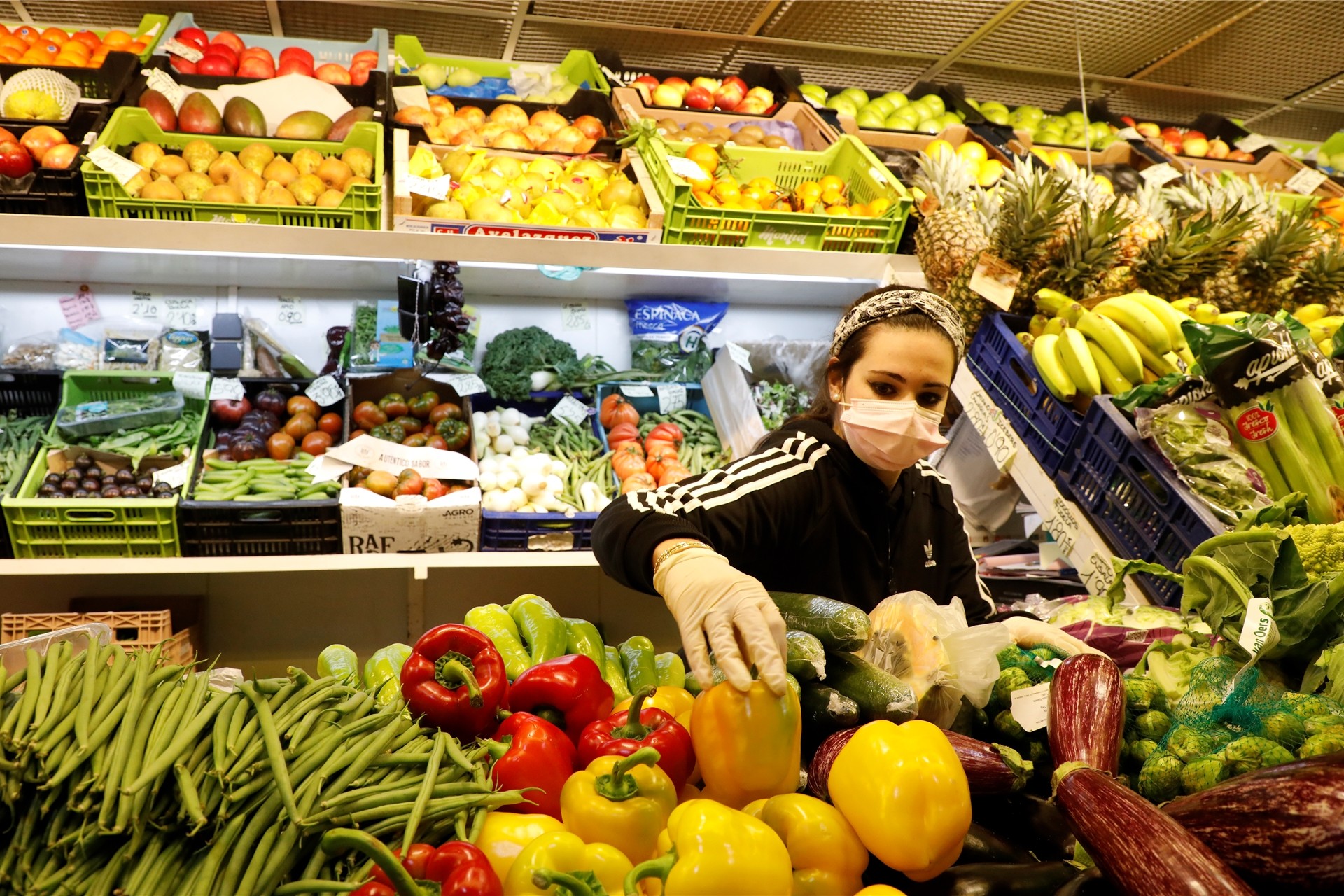 Eine Frau sortiert Gemüse in einem Supermarkt.