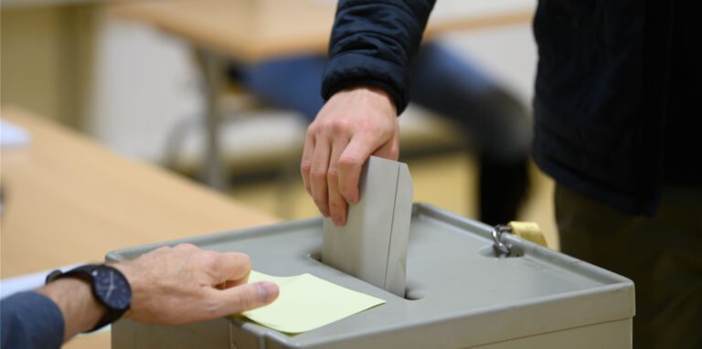 Ein Wähler wirft im Wahllokal seinen Stimmzettel in eine Wahlurne.