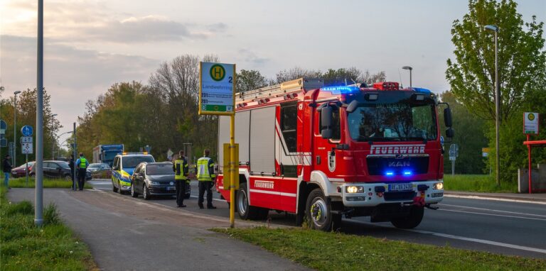 Im vorderen Bereich ist ein Feuerwehrwagen zu sehen. Dahinter stehen ein schwarzes Auto und ein Einsatzfahrzeug der Polizei. Weiter hinten auf dem Bild sind weitere Fahrzeuge zu erkennen.