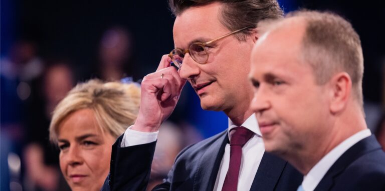 Hendrik Wüst (M, CDU), Ministerpräsident von Nordrhein-Westfalen, Mona Neubaur (l), Vorsitzende von Bündnis 90/Die Grünen in Nordrhein-Westfalen und Joachim Stamp (r, FDP), Minister für Kinder, Familie, Flüchtlinge und Integration und stellvertretender Ministerpräsident von Nordrhein-Westfalen, stehen vor Beginn der WDR-„Wahlarena: Der Fünfkampf“ in einem Fernsehstudio in Bocklemünd.