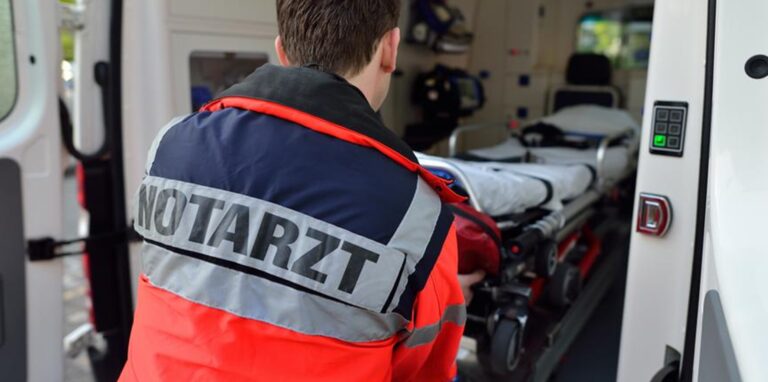 Ein Notarzt schiebt eine Trage in den Rettungswagen.