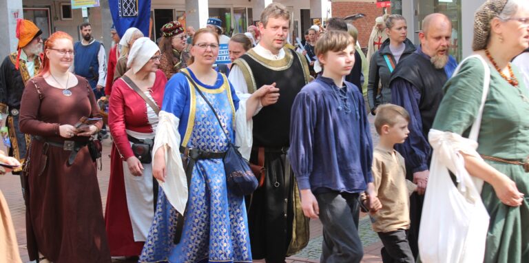 In altertümliche Gewänder gekleidet, laufen Mittelalter-Fans durch die Waltroper Fußgängerzone.
