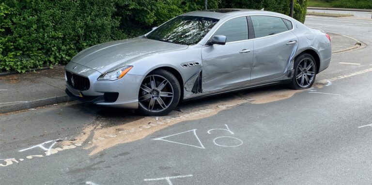 Ein an der Fahrerseite zerbeulter Maserati steht am Rand der Leveringhäuser Straße in Waltrop, auf die Straße sind polizeiliche Markierungen gezeichnet.