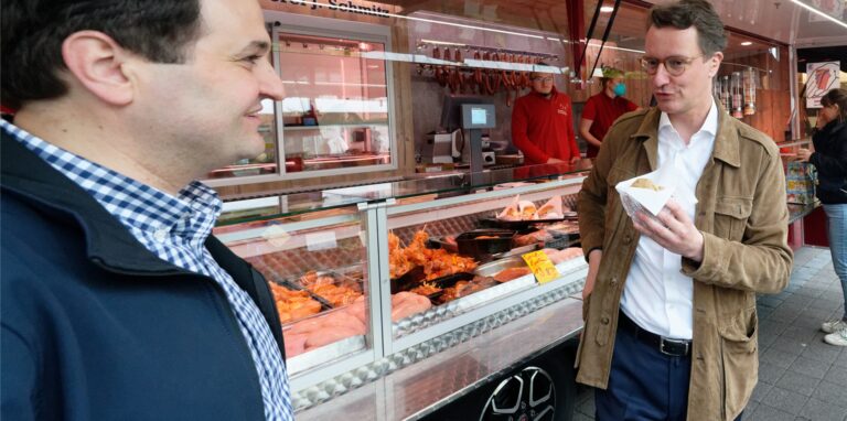 Hendrik Wüst, Spitzenkandidat der CDU zur Landtagwahl (r) und Landtagskandidat Nathanael Liminski (l), sprechen auf dem Markt auf dem Neptunplatz in Köln mit Marktbesuchern.