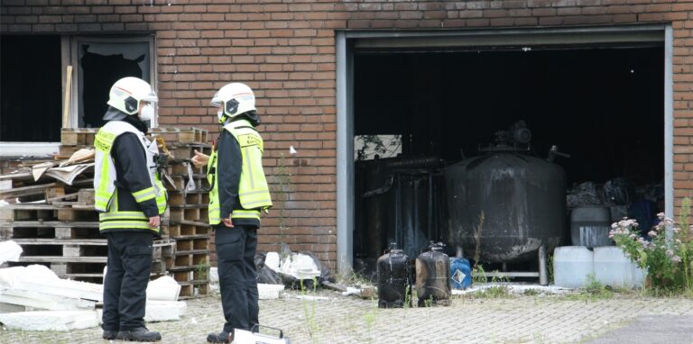 Einsatzkräfte der Feuerwehr vor der Hinterhof-Garage am Ostring in Herten, in der zahlreiche Gasflaschen und Chemikalienkanister lagerten.