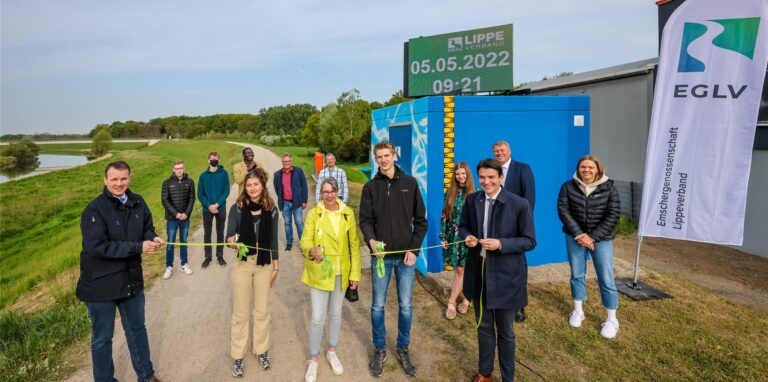 Beteiligte schneiden ein grünes Band am Pegelhäuschen der Lippe durch.
