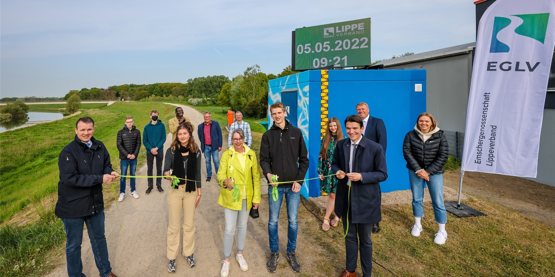 Beteiligte schneiden ein grünes Band am Pegelhäuschen der Lippe durch.
