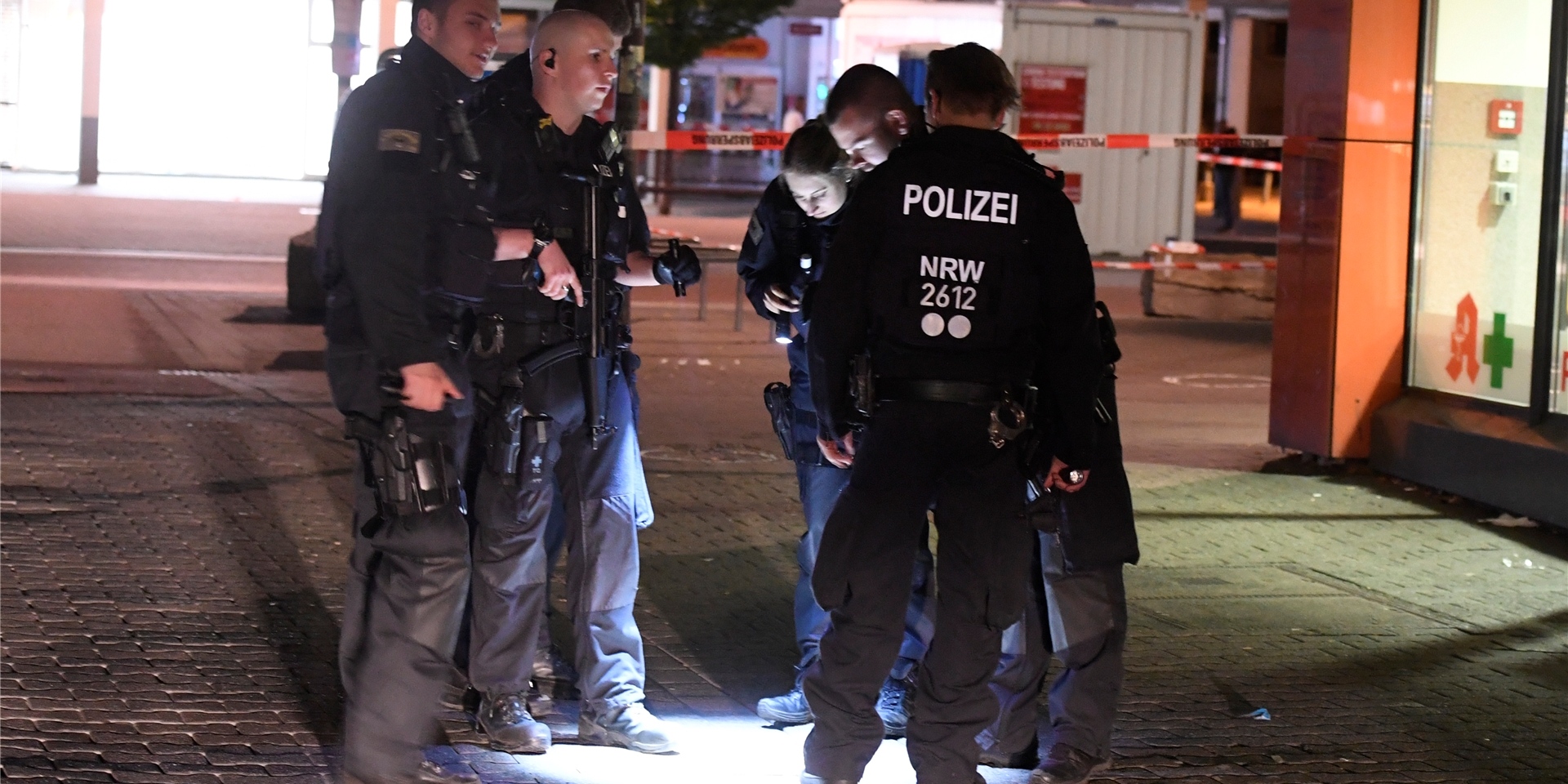 Polizisten suchen in der Nacht nach Spuren der Schiesserei auf dem Hamborner Altmarkt in Marxloh.