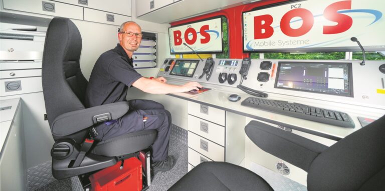 Ein Feuerwehrmann sitzt in einem Einsatzleitwagen der Feuerwehr.