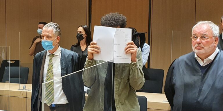 Angeklagte und Verteidiger im Prozess um Überfälle auf Prostituierte in Recklinghausen stehen in einem Sitzungssaal des Landgerichts Bochum