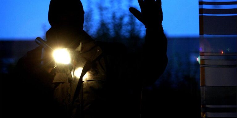 Symbolbild Einbruch: Eine Silhouette eines Mannes mit Sturmhaube und Taschenlampe ist an einem Fenster zu sehen.