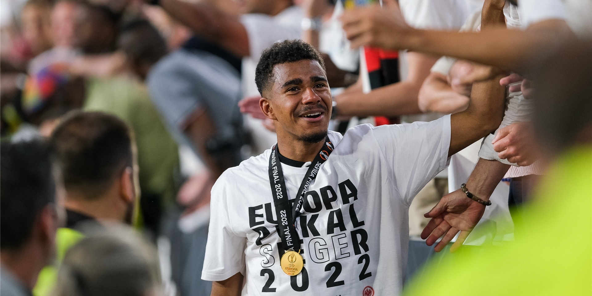 BVB-Leihspieler Ansgar Knauff hat eine Medaille um den Hals hängen, auf seinem Shirt steht: „EUROPA POKAL SIEGER 2022“.
