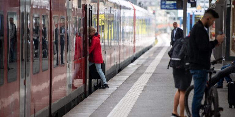 Eine Zugreisende steigt am Stuttgarter Hauptbahnhof in einen Regionalzug der Deutschen Bahn ein.