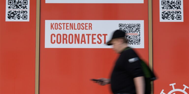 Ein Passant geht an einem Corona-Testcenter entlang.