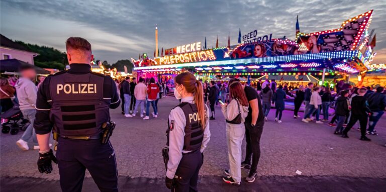 Polizeibeamte stehen auf dem Kirmesgelände Hohen Steinert.