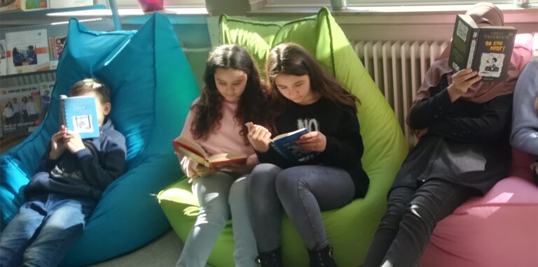 Schüler sitzen auf Sitzsäcken und lesen.