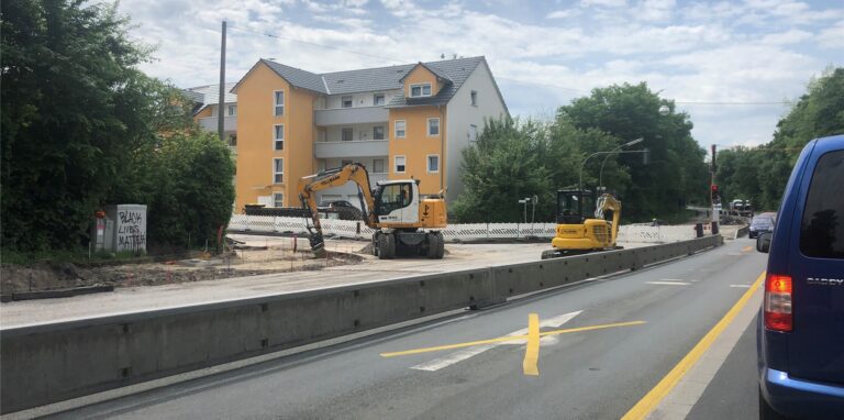 Blick auf eine Straßenkreuzung; im Baustellenbereich stehen zwei Bagger.