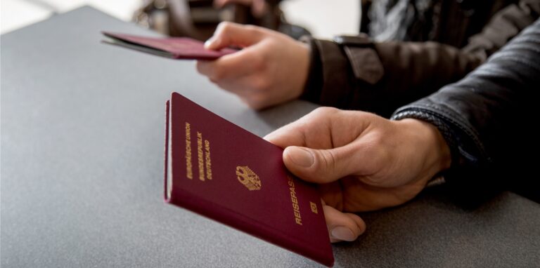 Ein Mann hält einen Reisepass in der Hand