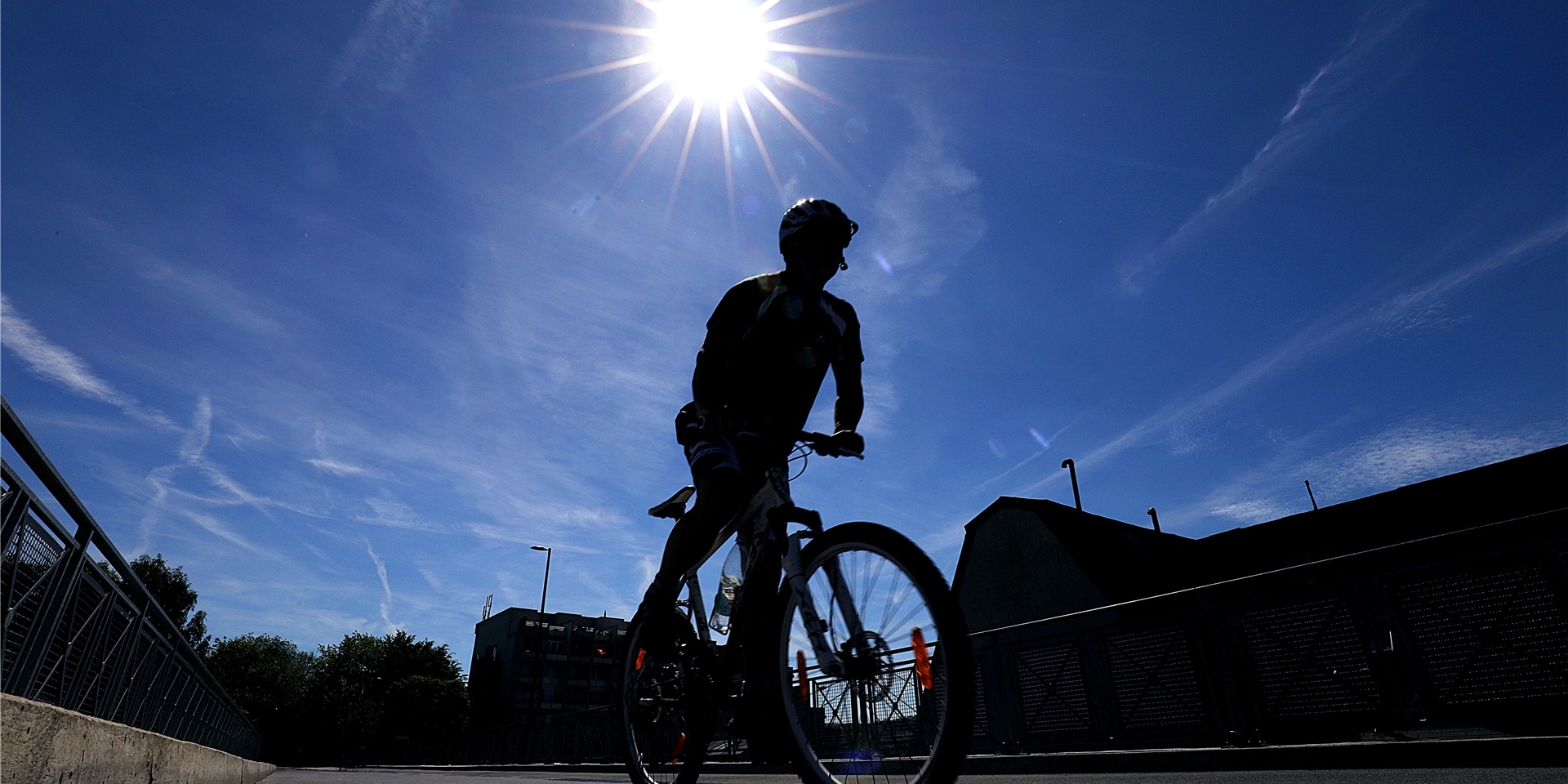 Symbolbild: Silhouette eines Radfahrers vor blauem Himmel.
