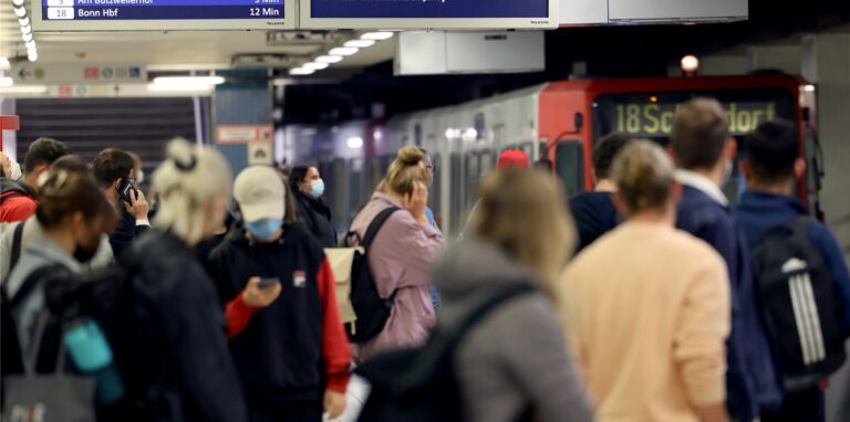 Fahrgäste stehen in einer U-Bahnstation am Bahnsteig.
