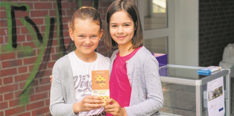 Zwei Mädchen halten eine Tafel Fairtrade-Schokolade