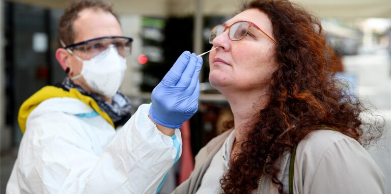 Ein Intensivpfleger testet eine Passantin mit einem Antigen-Schnelltest. Immer weniger Menschen auch in Herten lassen sich dagegen eine mögliche Corona-Infektion durch einen anschließenden PCR-Test sicher bestätigen.