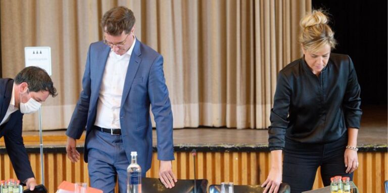 NRW-Ministerpräsident Hendrik Wüst (l.) und die Grünen-Vorsitzende in NRW, Mona Neubaur, nehmen bei einer Pressekonferenz Platz.