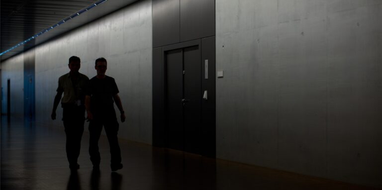 Zwei Männer gehen am 25.07.2013 während der Sondersitzung des Parlamentarischen Kontrollgremiums (PKGr) im Bundestag in Berlin am Sitzungsaal vorbei.